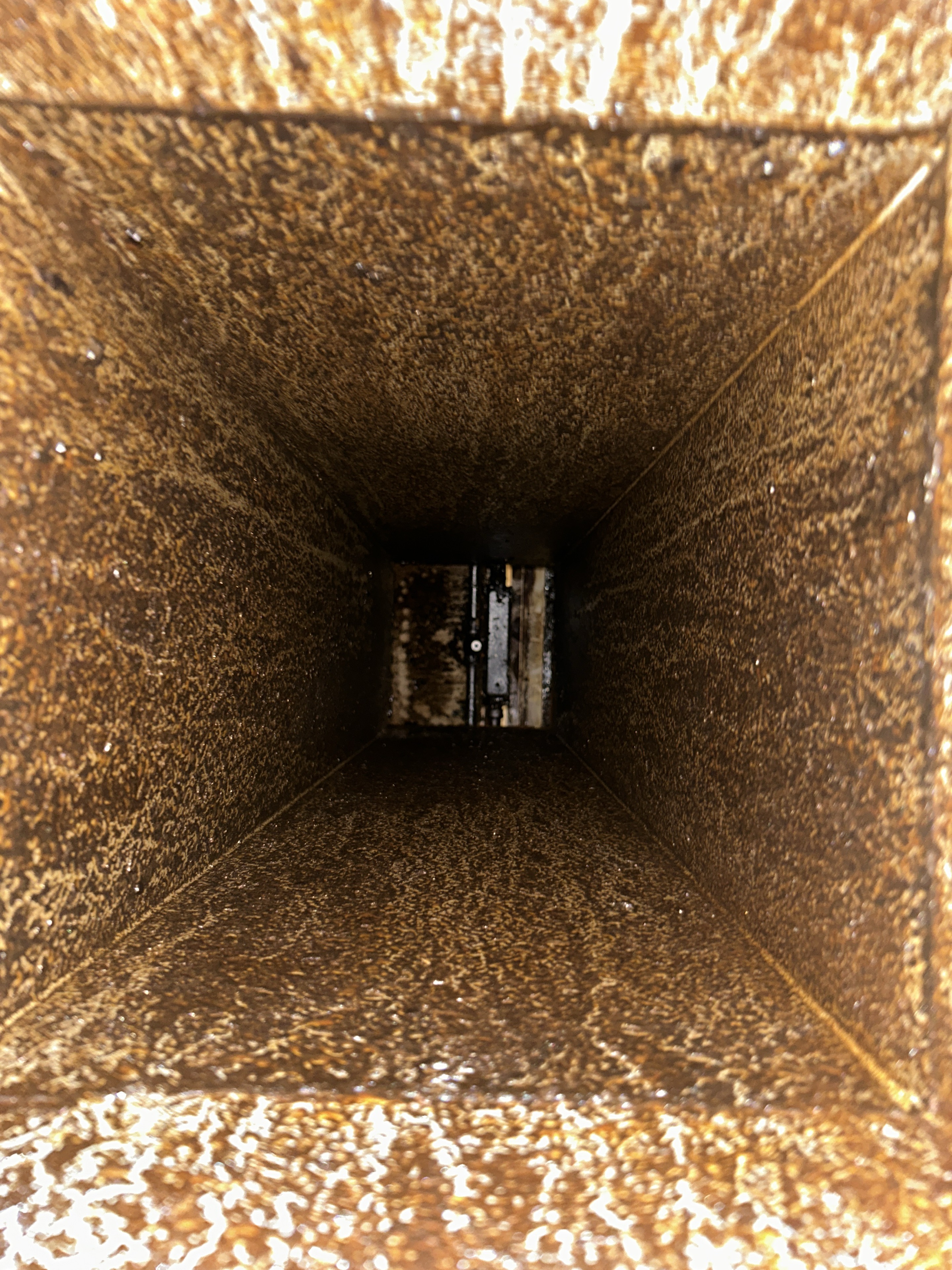 Square exhaust duct before cleaning, coated with grease